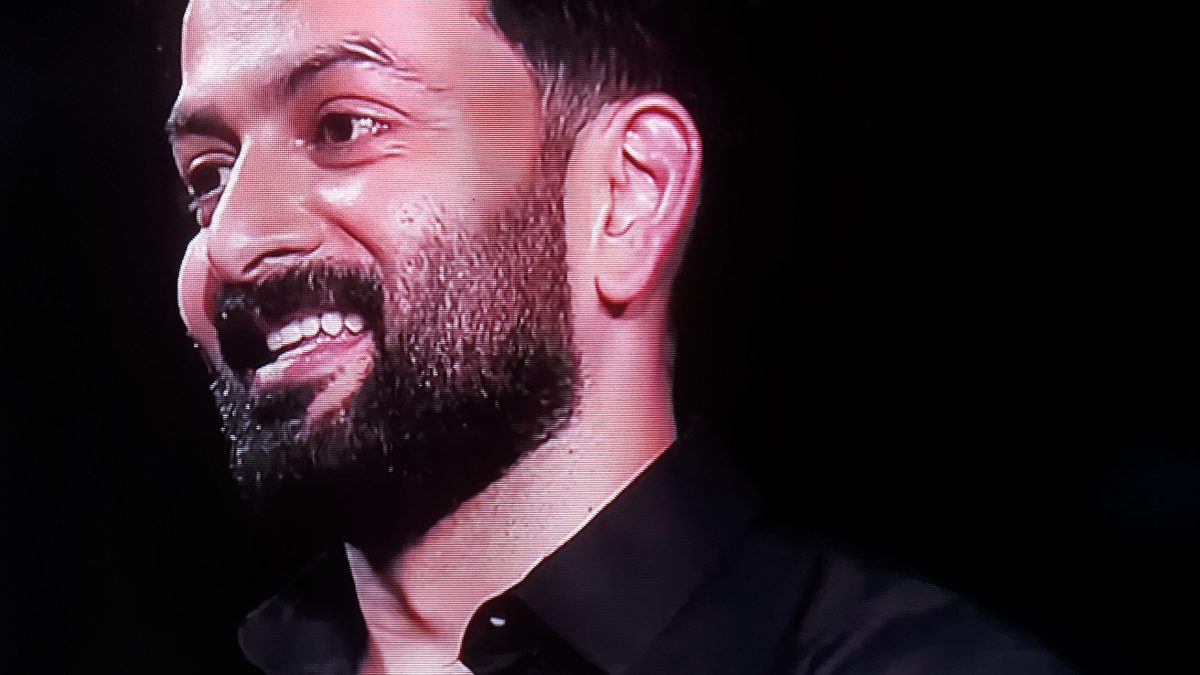 Prithviraj Sukumaran with a trimmed beard, smiling, in a black shirt