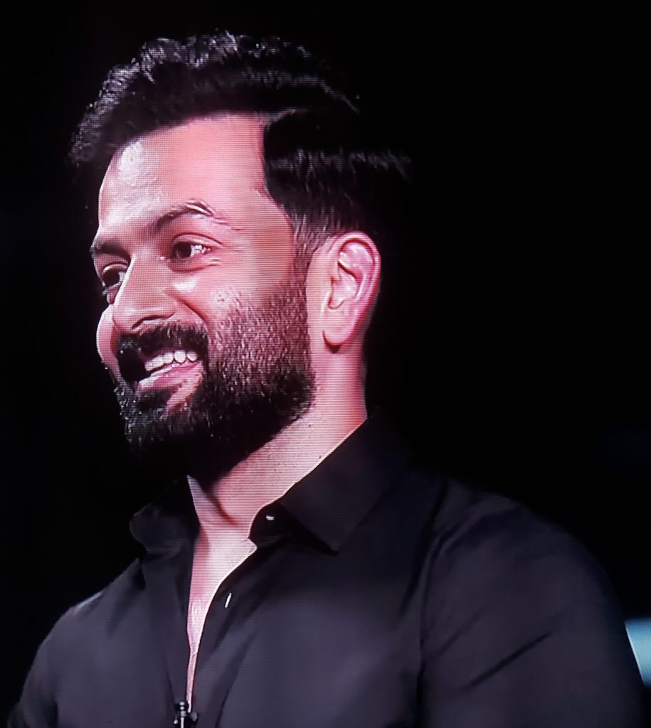 Prithviraj Sukumaran with a trimmed beard, smiling, in a black shirt
