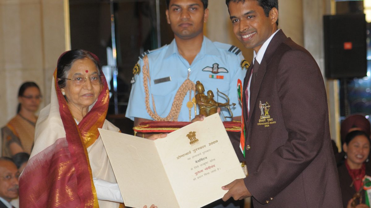 Pullela Gopichand in a dark blazer receiving the Dronacharya Award from President Pratibha Patil