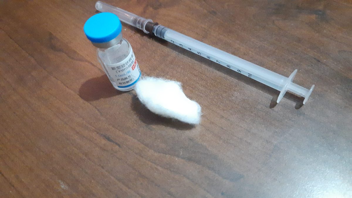 A vaccine vial, cotton swab and syringe