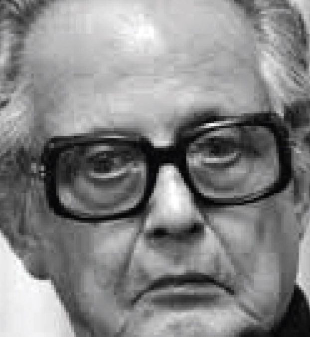 A black-and-white close-up of R. K. Laxman in thick-framed glasses