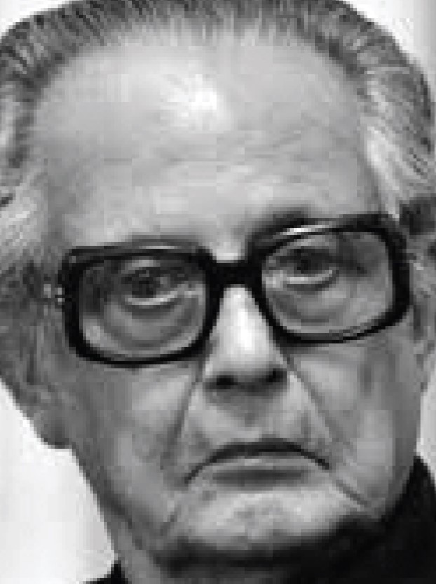A black-and-white close-up of R. K. Laxman in thick-framed glasses