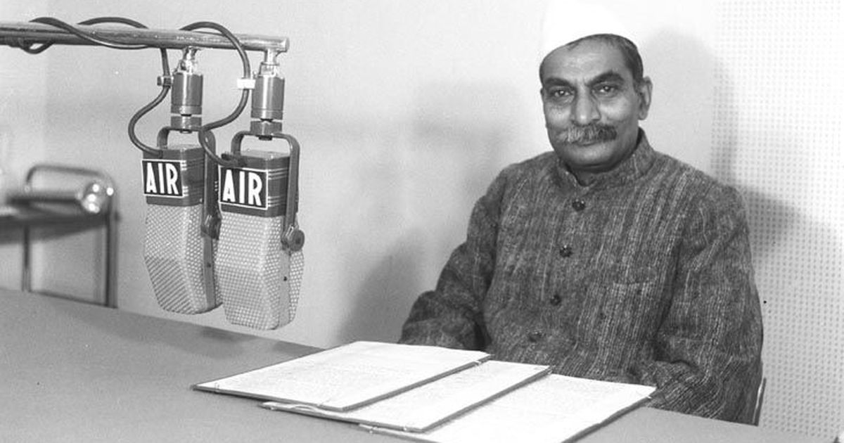 Rajendra Prasad seated at a desk with All India Radio microphones