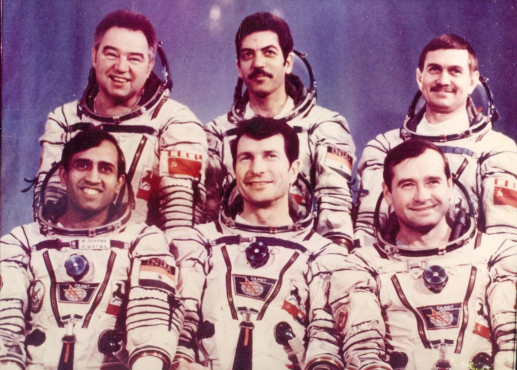 Six cosmonauts in white spacesuits, among them Rakesh Sharma, posing for an official photograph
