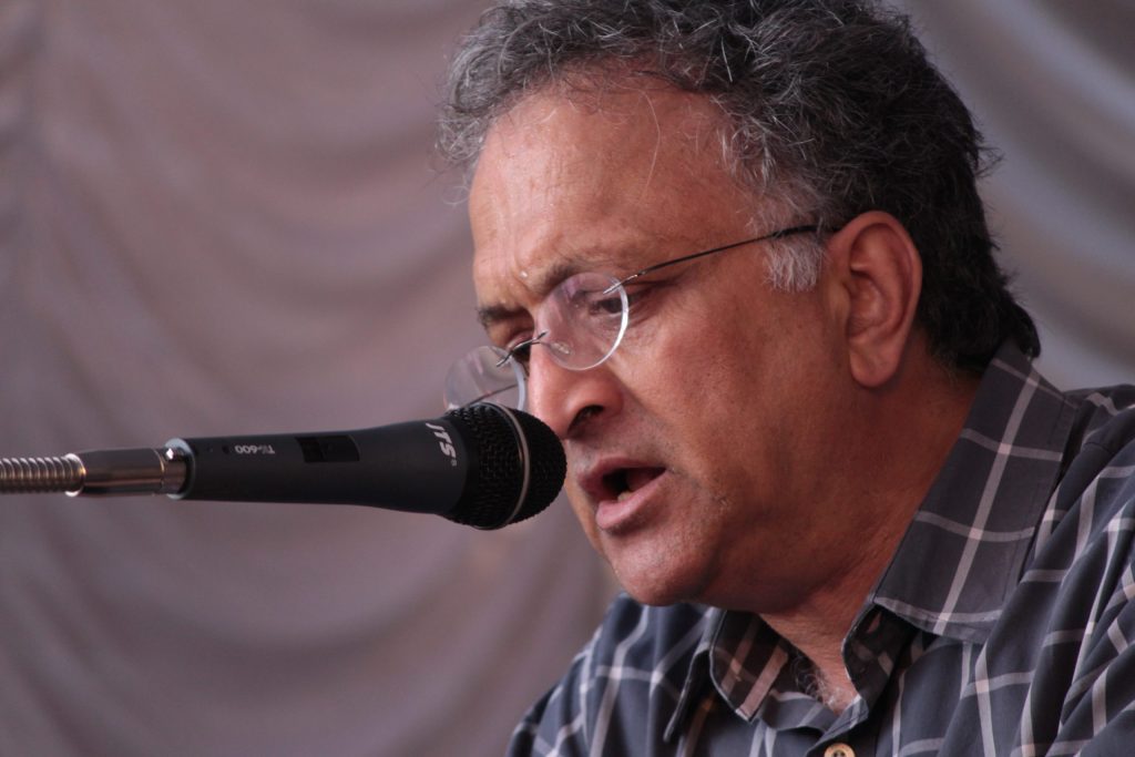 Close-up of Ramachandra Guha in glasses speaking into a microphone