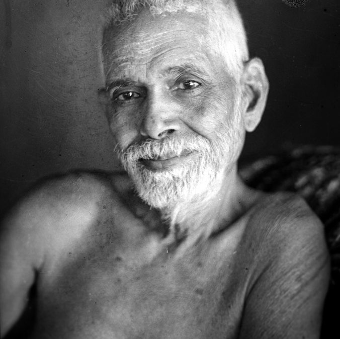 Black-and-white portrait of Ramana Maharshi with white hair and beard, bare-shouldered