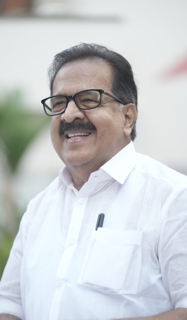 Ramesh Chennithala in glasses and a white shirt, smiling