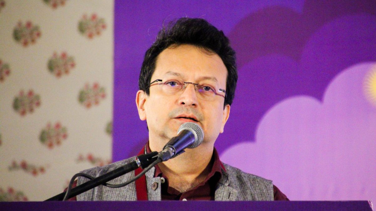 Ranjit Hoskote in glasses and a dark kurta speaking into a microphone