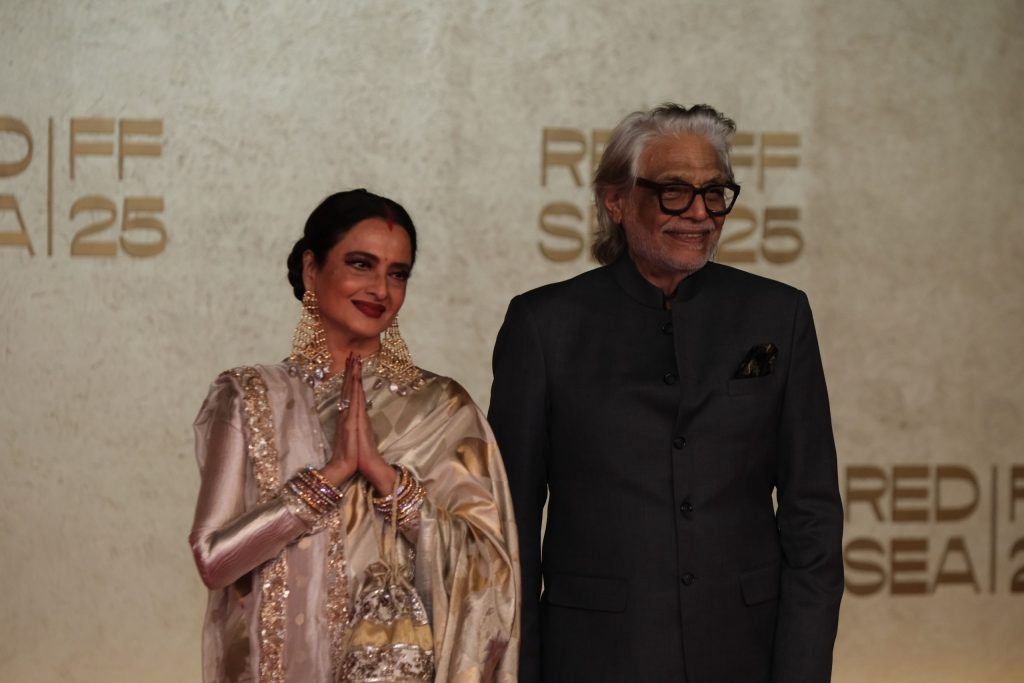 Rekha greeting with folded hands beside director Muzaffar Ali at the Red Sea Film Festival