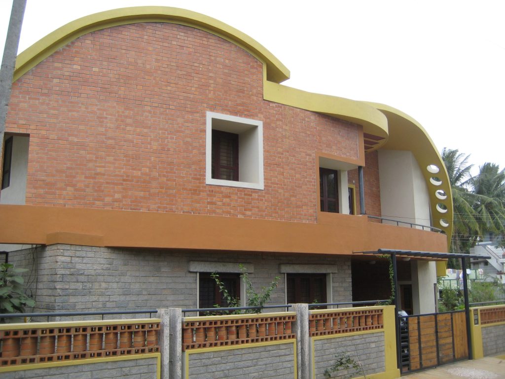 A modern brick house with a curved roof in Mysore