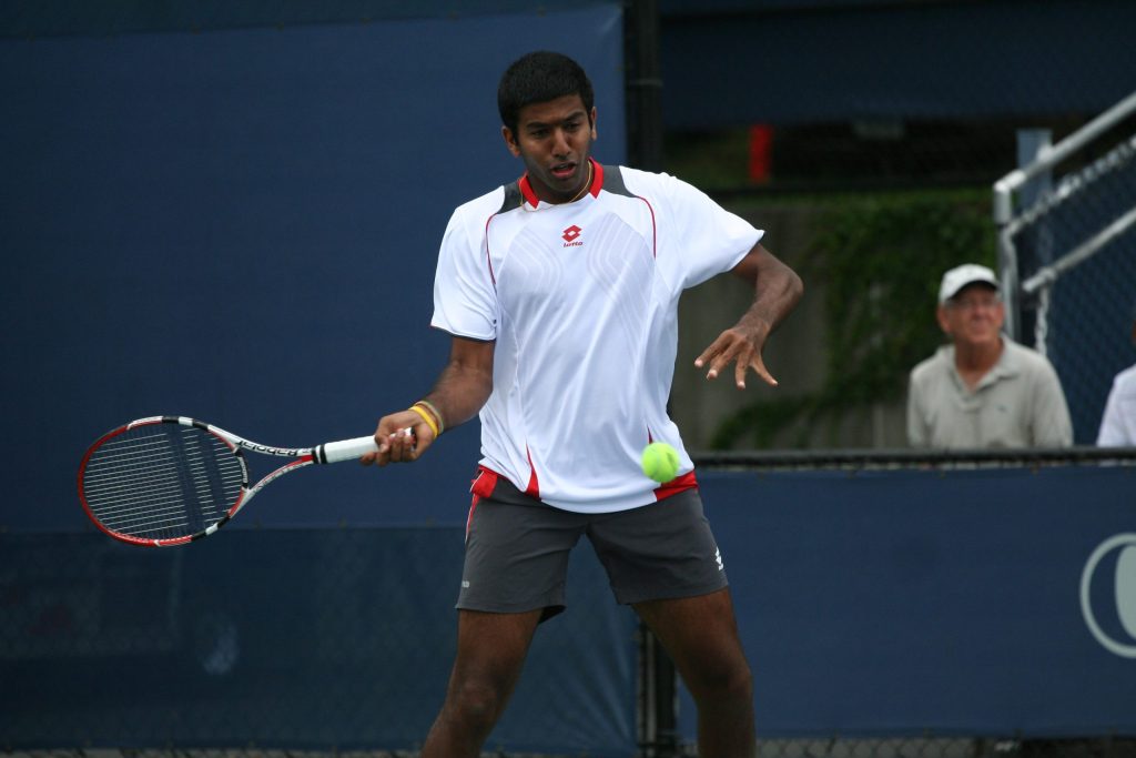 Rohan Bopanna on court in a white shirt, about to play a forehand