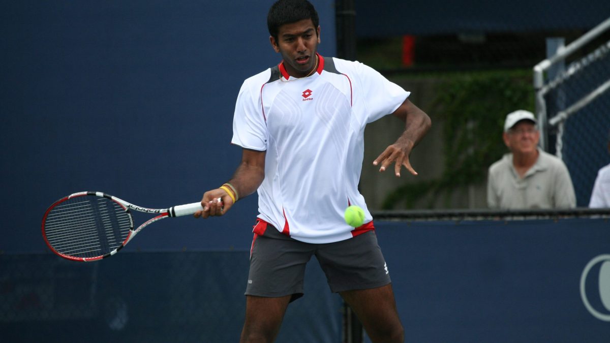 Rohan Bopanna on court in a white shirt, about to play a forehand