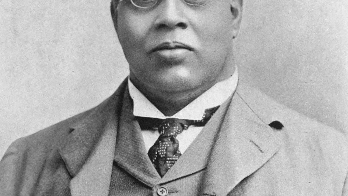 Black-and-white portrait of Romesh Chunder Dutt in glasses, a suit and waistcoat
