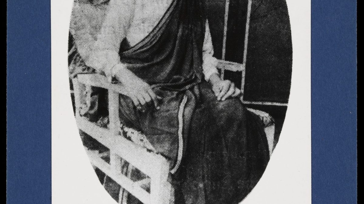 Oval photograph of Rukhmabai seated in a sari, mounted on a card with her name