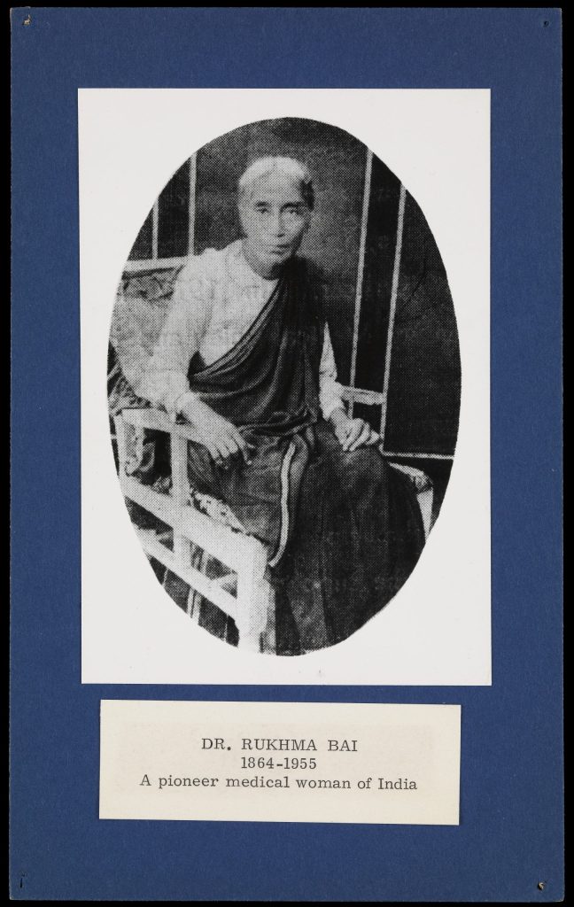 Oval photograph of Rukhmabai seated in a sari, mounted on a card with her name