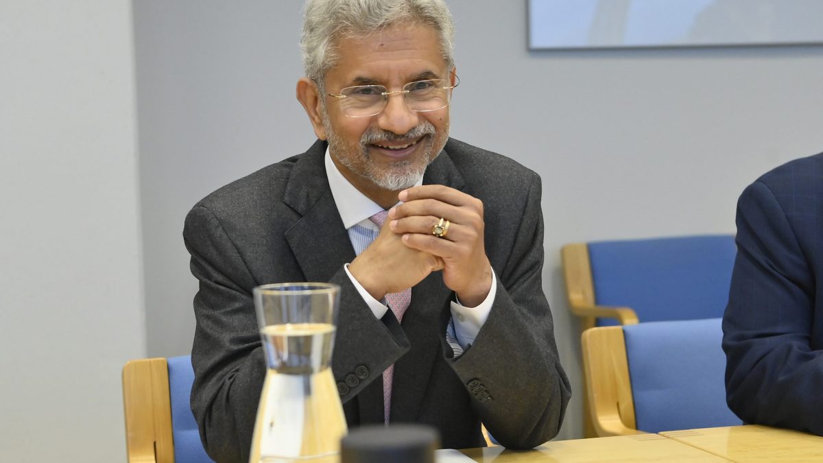 S. Jaishankar smiling with his hands clasped at a meeting table in Vienna