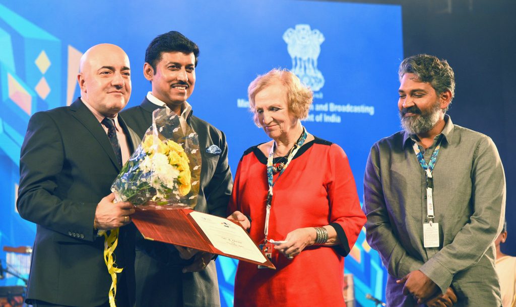 S. S. Rajamouli with a beard standing with other guests at a film festival ceremony