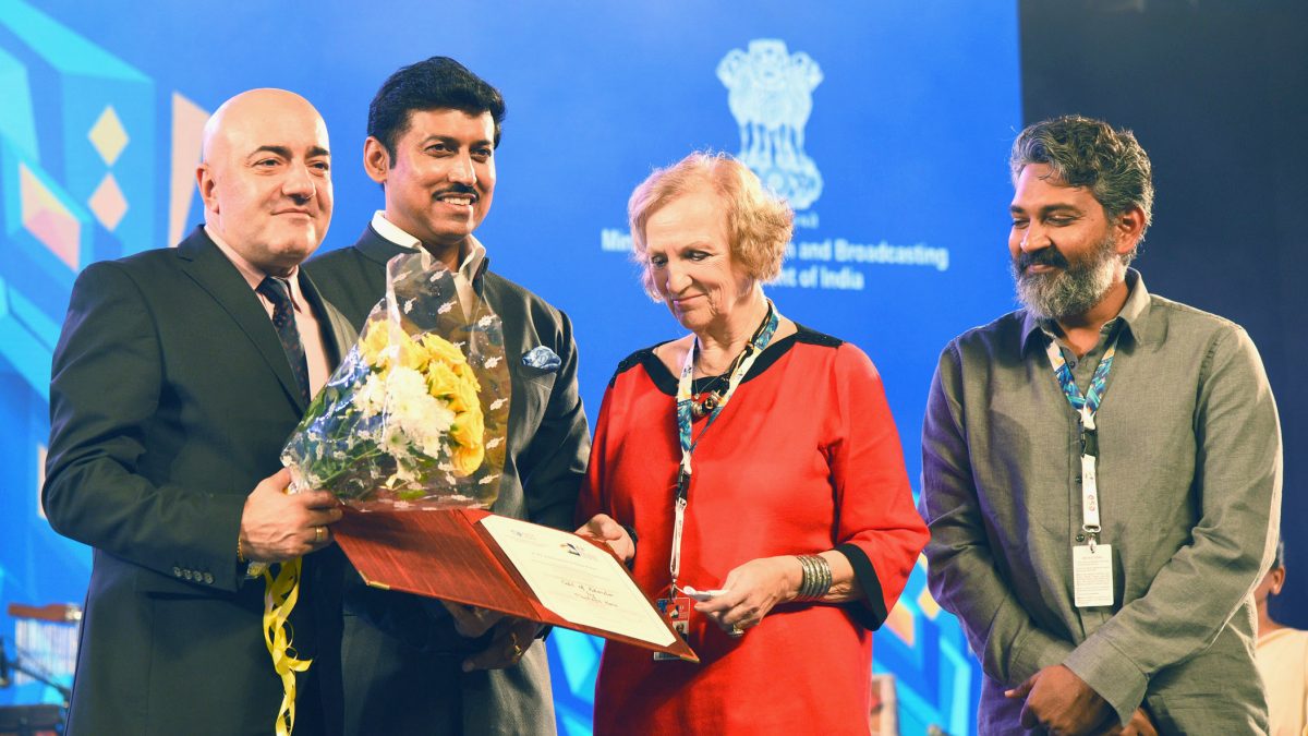 S. S. Rajamouli with a beard standing with other guests at a film festival ceremony