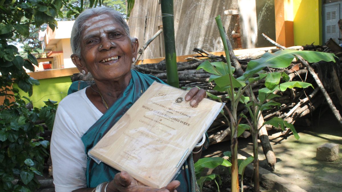 Saalumarada Thimmakka smiling and holding up a certificate outdoors