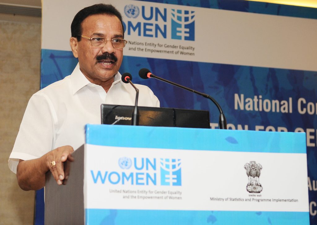 D. V. Sadananda Gowda in a white shirt speaking at a lectern with a UN Women logo