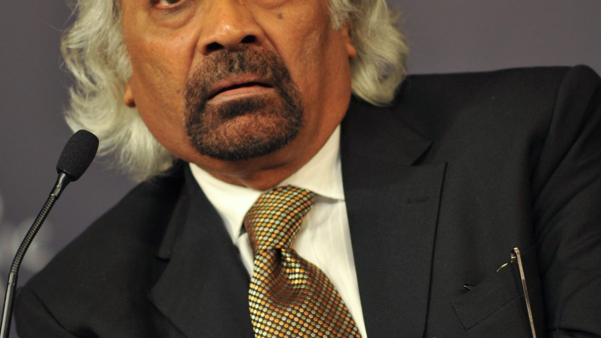 Sam Pitroda in a dark suit, gesturing as he speaks