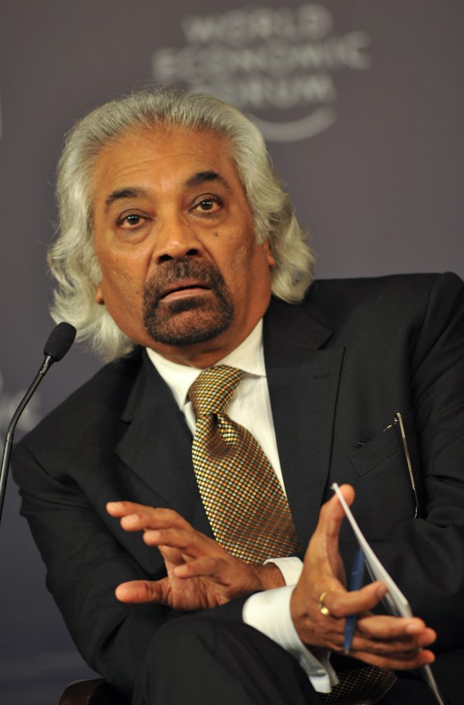 Sam Pitroda in a dark suit, gesturing as he speaks