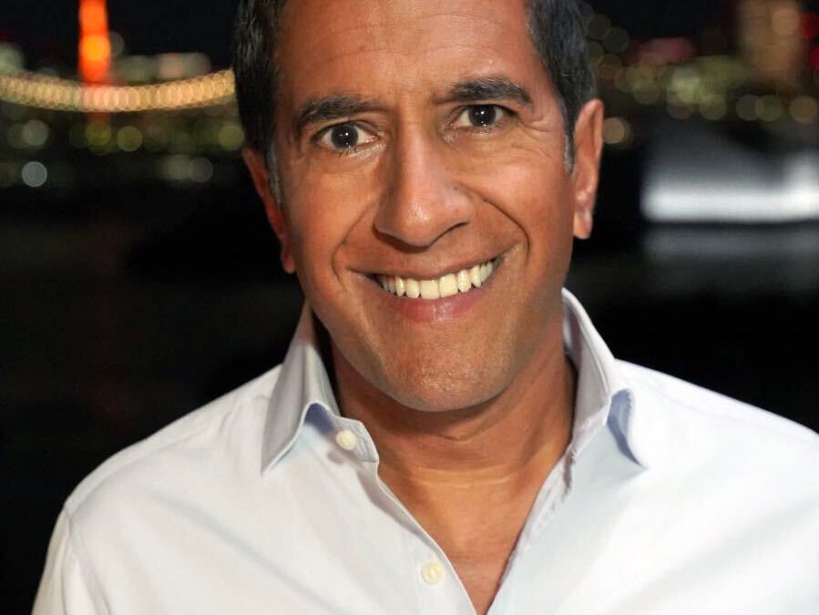 Sanjay Gupta smiling, in a dark shirt
