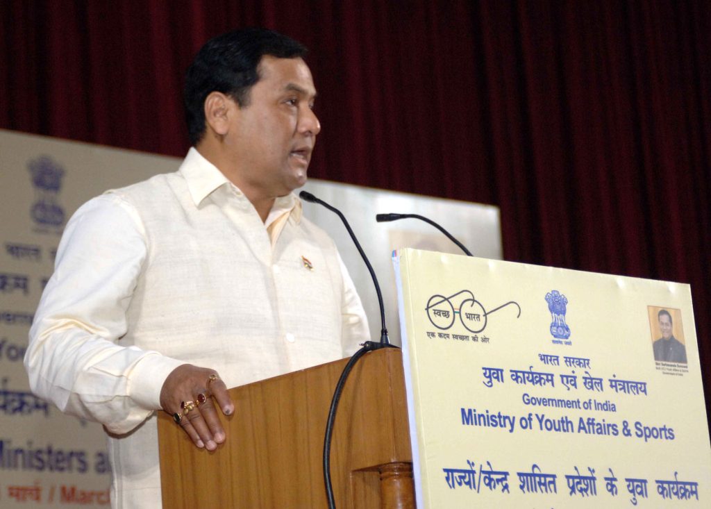 Sarbananda Sonowal in a white kurta speaking at a lectern