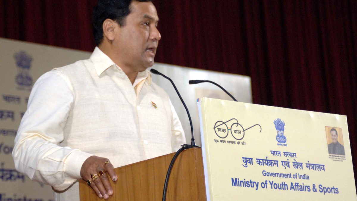 Sarbananda Sonowal in a white kurta speaking at a lectern