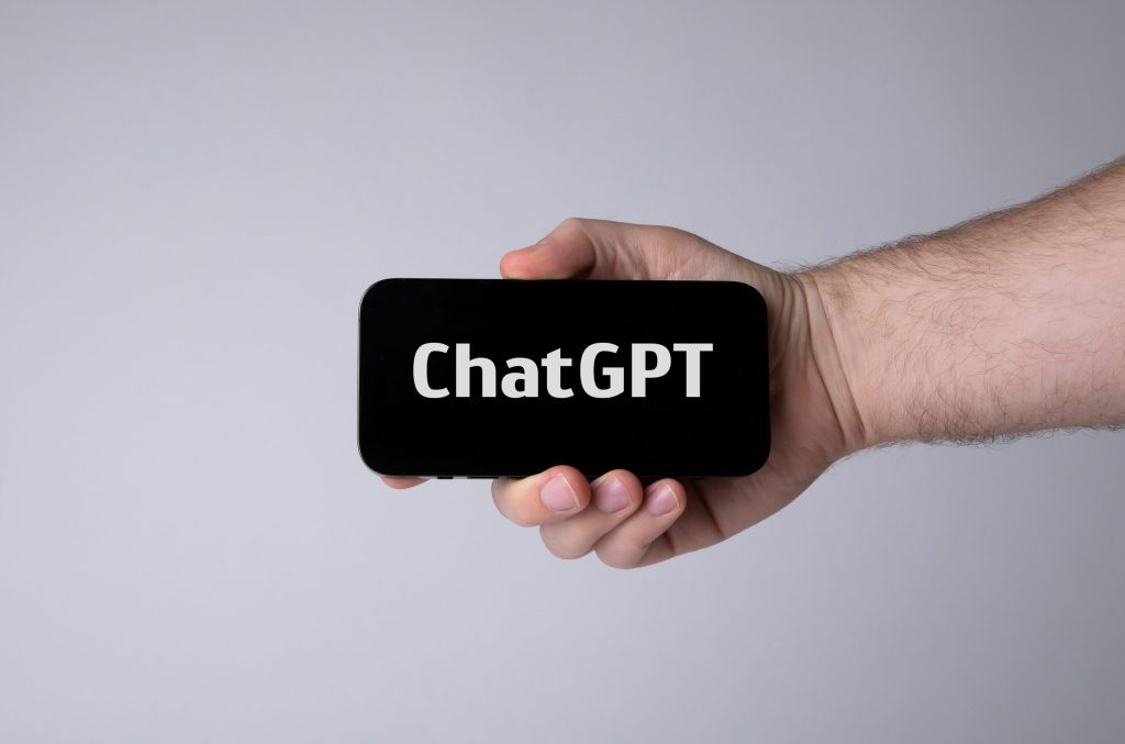 A hand holding a smartphone with an AI chatbot on screen