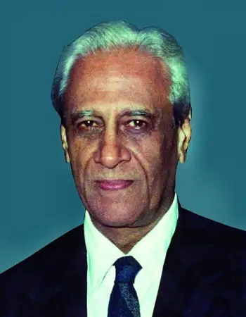 An official portrait of Satish Dhawan with white hair, in a dark suit and tie
