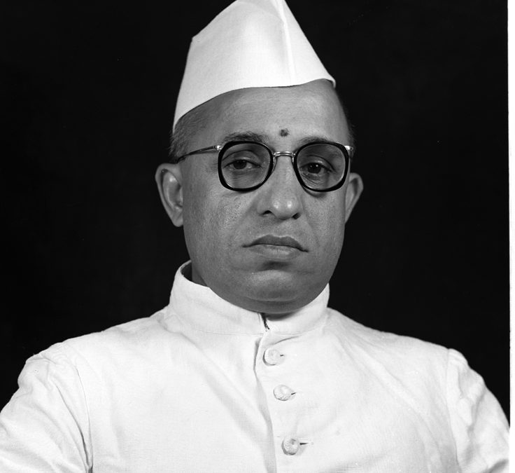 A black-and-white portrait of Semmangudi Srinivasa Iyer in a white cap and glasses