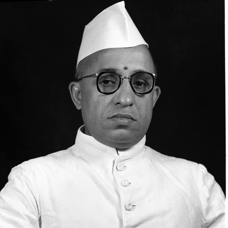 A black-and-white portrait of Semmangudi Srinivasa Iyer in a white cap and glasses