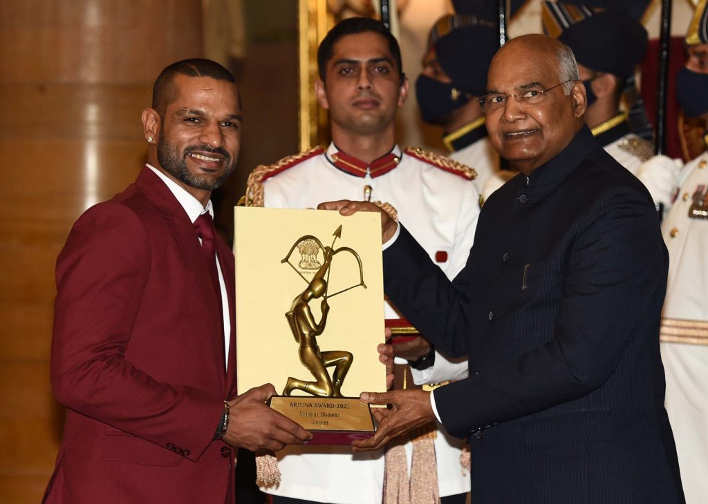 Shikhar Dhawan in a maroon blazer receiving the Arjuna Award from President Ram Nath Kovind