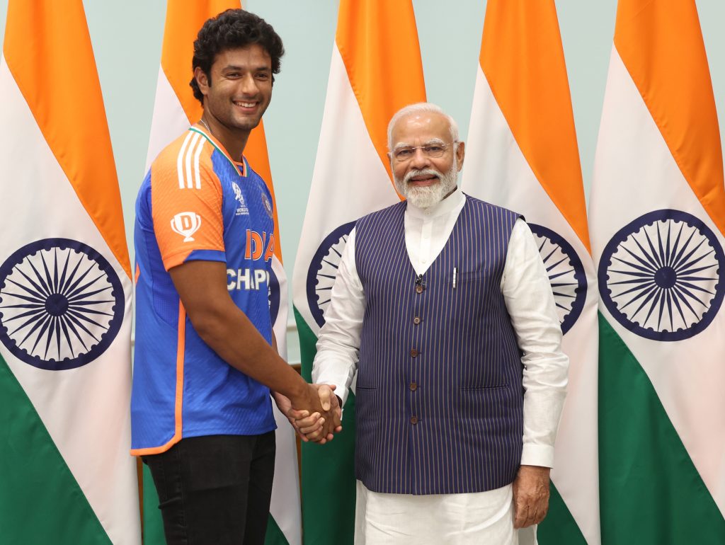 Shivam Dube in India's champions jersey shaking hands with Prime Minister Narendra Modi