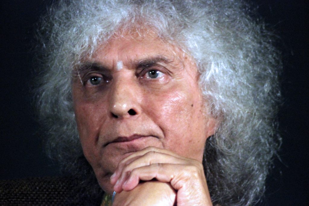 Close-up of Shivkumar Sharma with a halo of white curly hair, hand to his chin