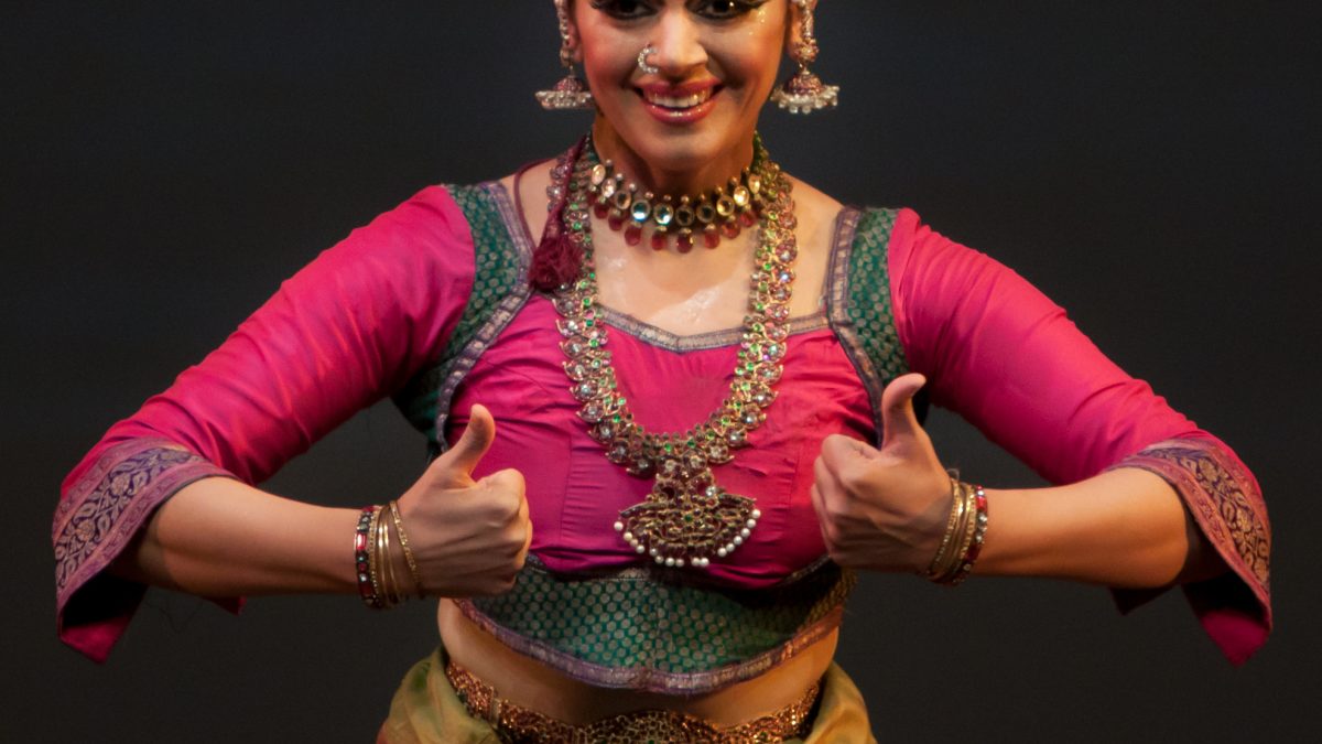 Shobana in a pink and green Bharatanatyam costume, mid-pose on stage