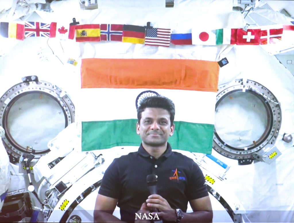 Shubhanshu Shukla smiling in front of the Indian flag aboard the International Space Station