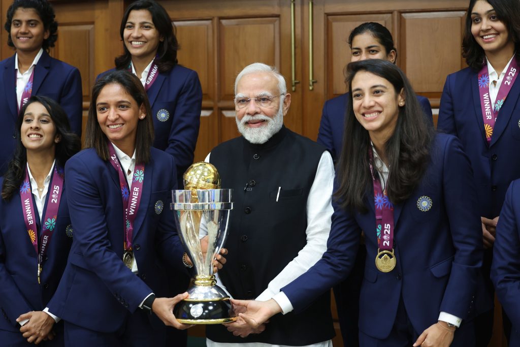 Members of the Indian women's cricket team with the World Cup trophy and the Prime Minister