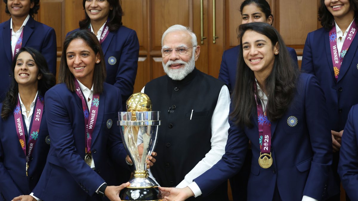 Members of the Indian women's cricket team with the World Cup trophy and the Prime Minister
