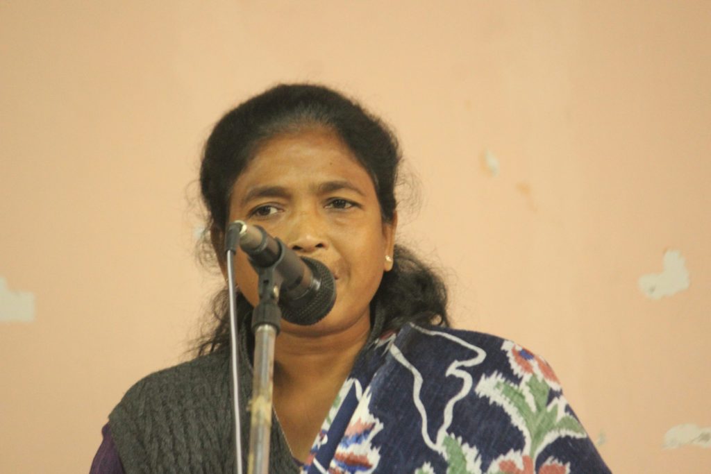 Soni Sori speaking into a microphone at a public meeting