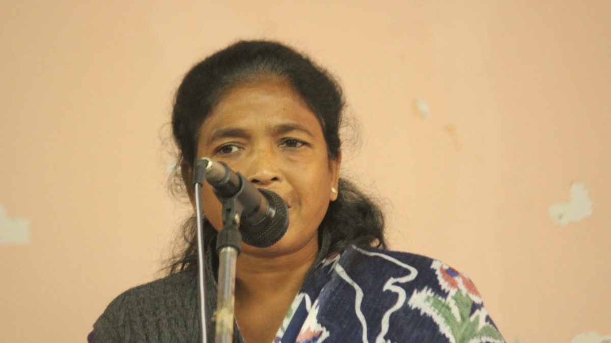Soni Sori speaking into a microphone at a public meeting