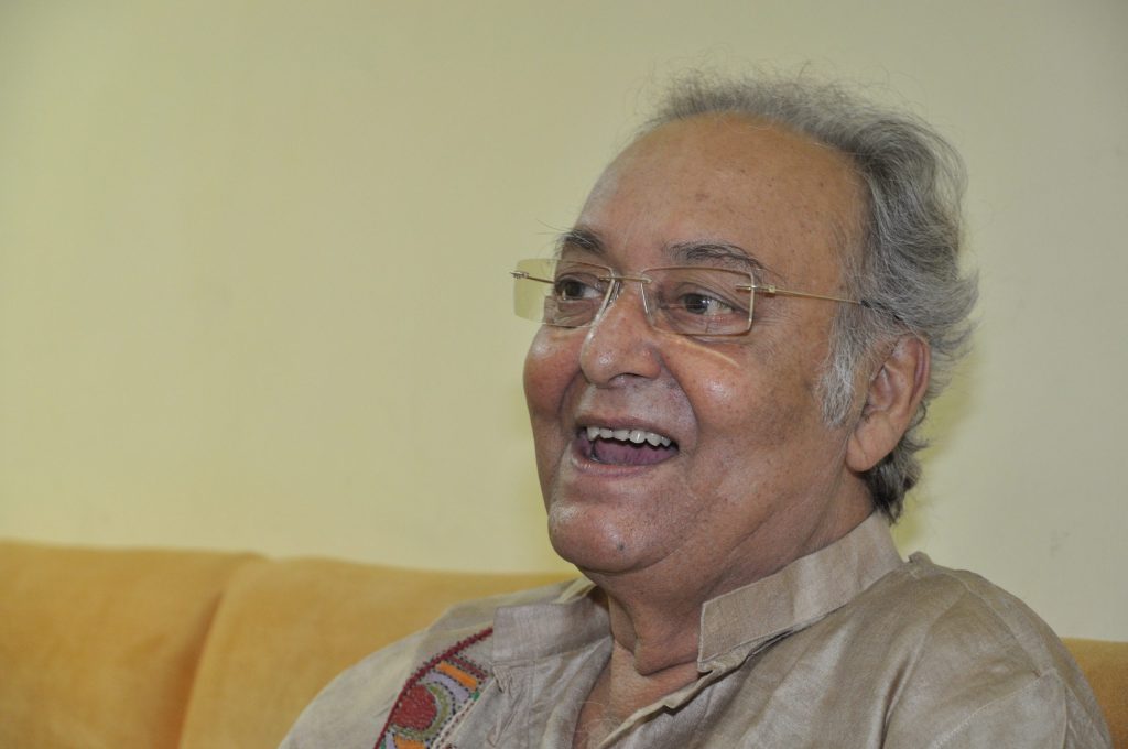 Soumitra Chatterjee with white hair, laughing, in a light kurta
