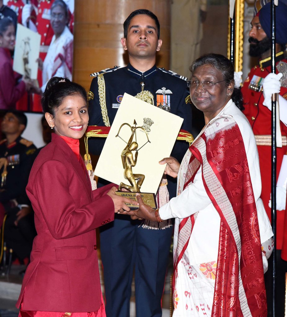 Sreeja Akula in a maroon blazer receiving the Arjuna Award from President Droupadi Murmu