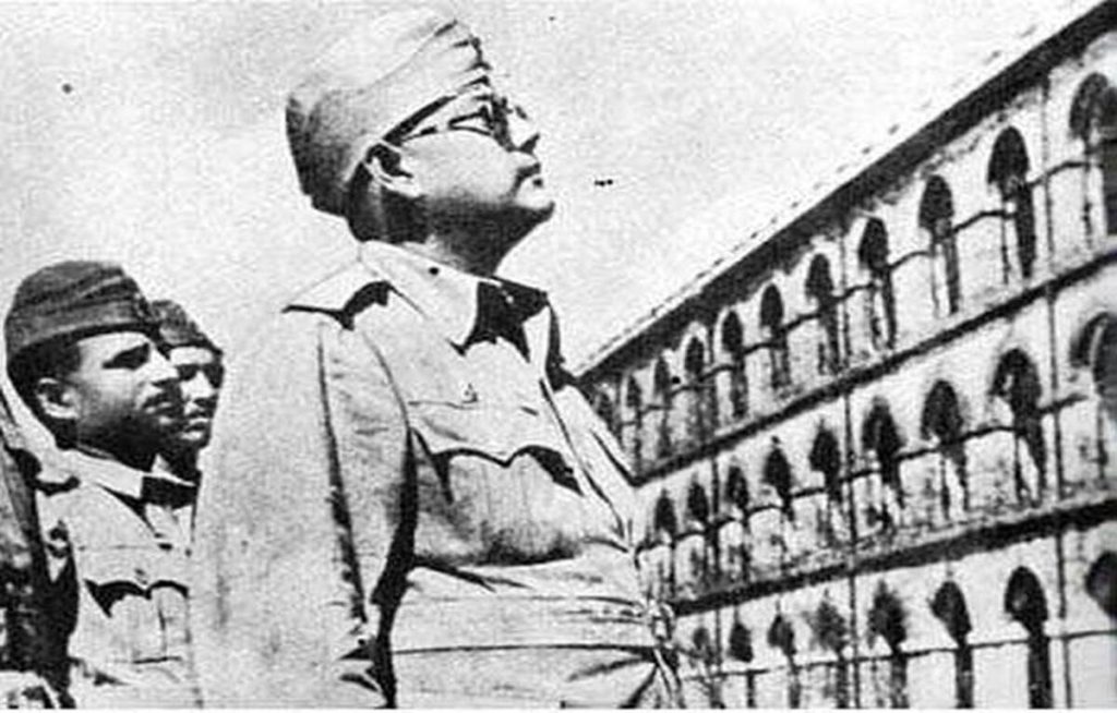 Subhas Chandra Bose in military uniform and cap looking upward