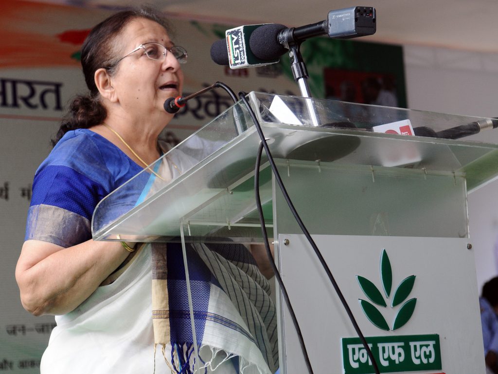 Sumitra Mahajan in a blue sari speaking at a lectern