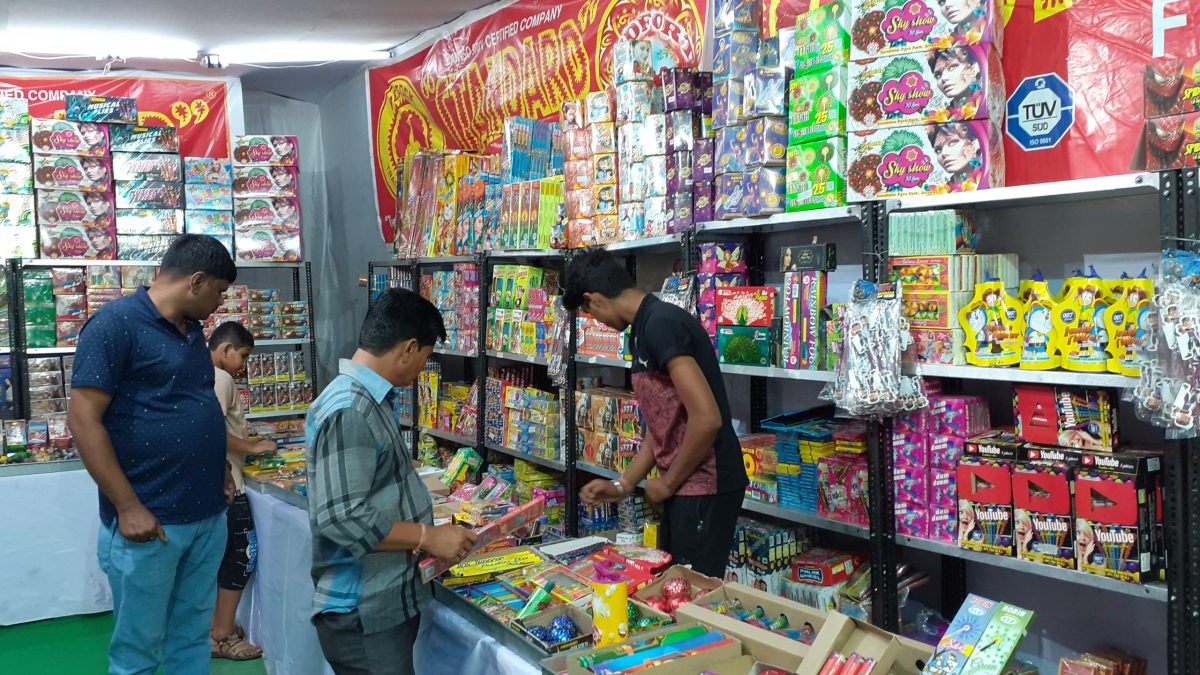 Shoppers browsing boxes of firecrackers at a stall