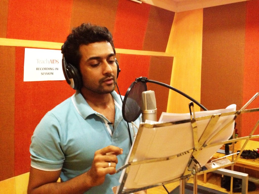 Suriya wearing headphones, recording at a studio microphone