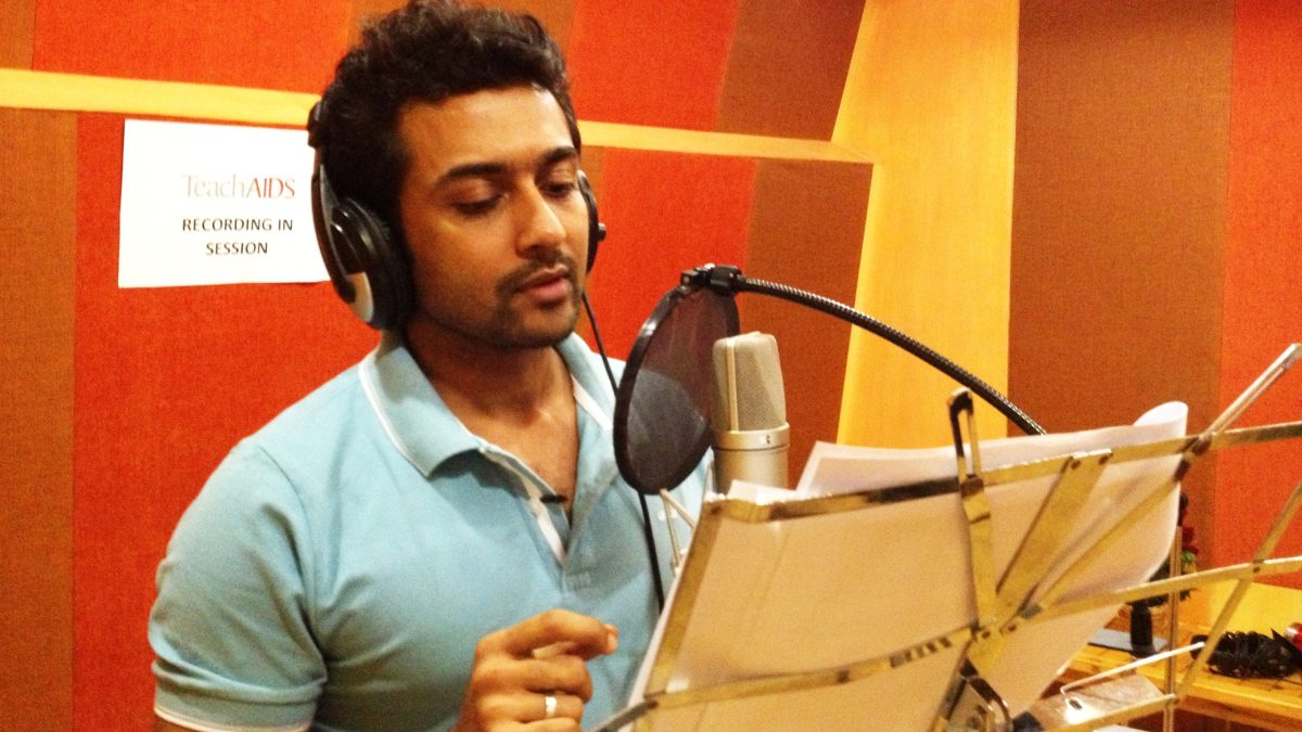 Suriya wearing headphones, recording at a studio microphone