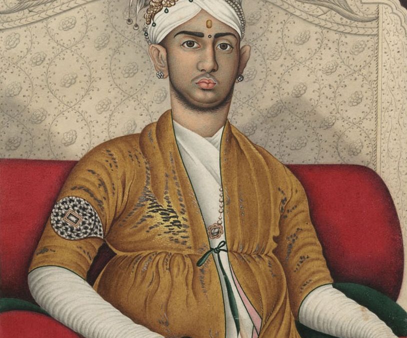 Painted portrait of Swathi Thirunal in a turban and yellow robe, seated against a red cushion